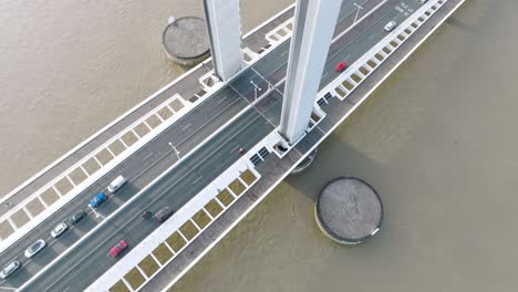 vehicle traffic crossing the jacques chaban delmas lift bridge over the garonne river in bordeaux france to bassins à flots neighborhood , aerial looking down tilt up shot