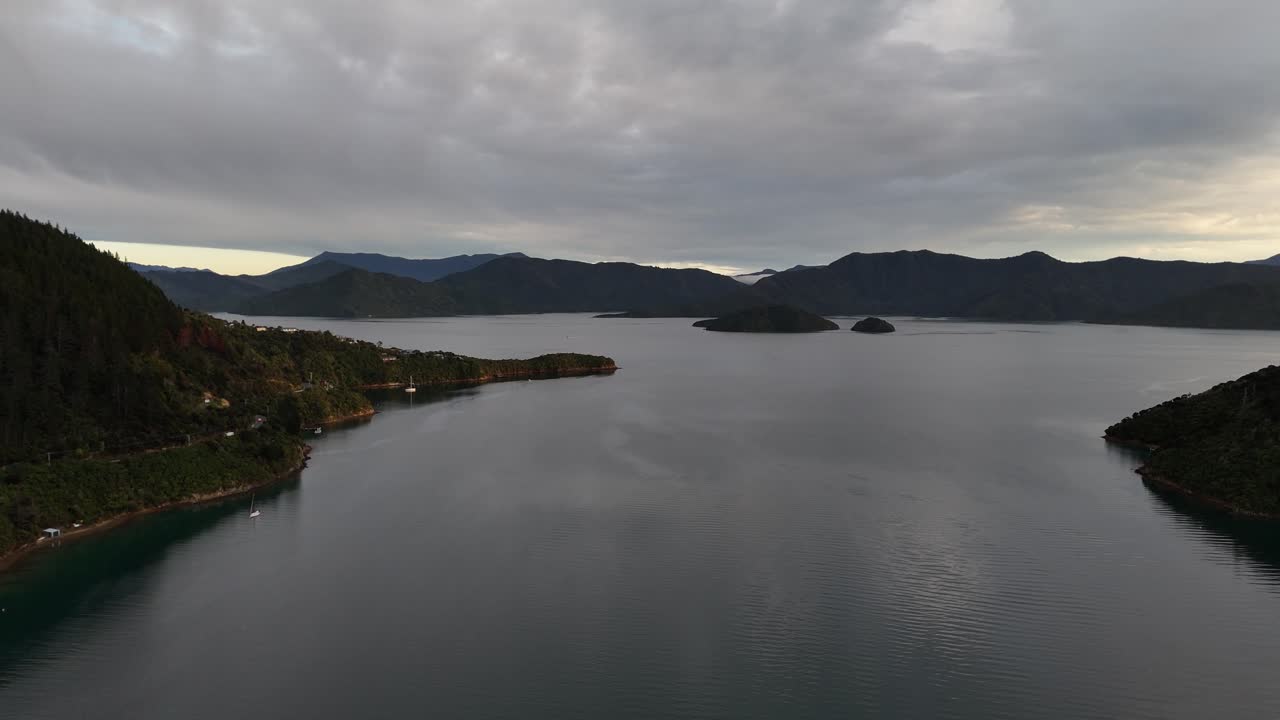 Aerial drone view over serene lakes nestled between majestic mountains in the Picton area, South Island, New Zealand, under a dramatic cloudy sky. Scenic nature landscape