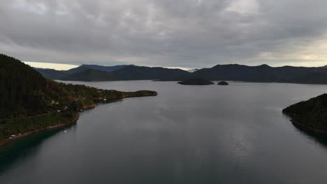 aerial drone view over serene lakes nestled between majestic mountains in the picton area, south island, new zealand, under a dramatic cloudy sky. scenic nature landscape
