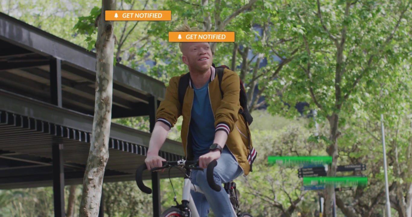 Happy Young Man with Albinism Riding a Bicycle in a City Park