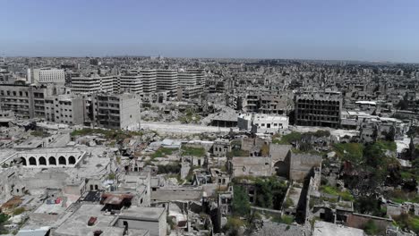buildings of aleppo in syria 10 years after the civil war. we can see grass covering ruins of building, destroyed after bombing - aerial view with a drone 4k