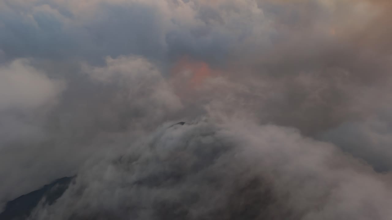 Volcan de Fuego, near Antigua Guatamala, aerial drone view at dusk of the volcano cone partially covered by cloud