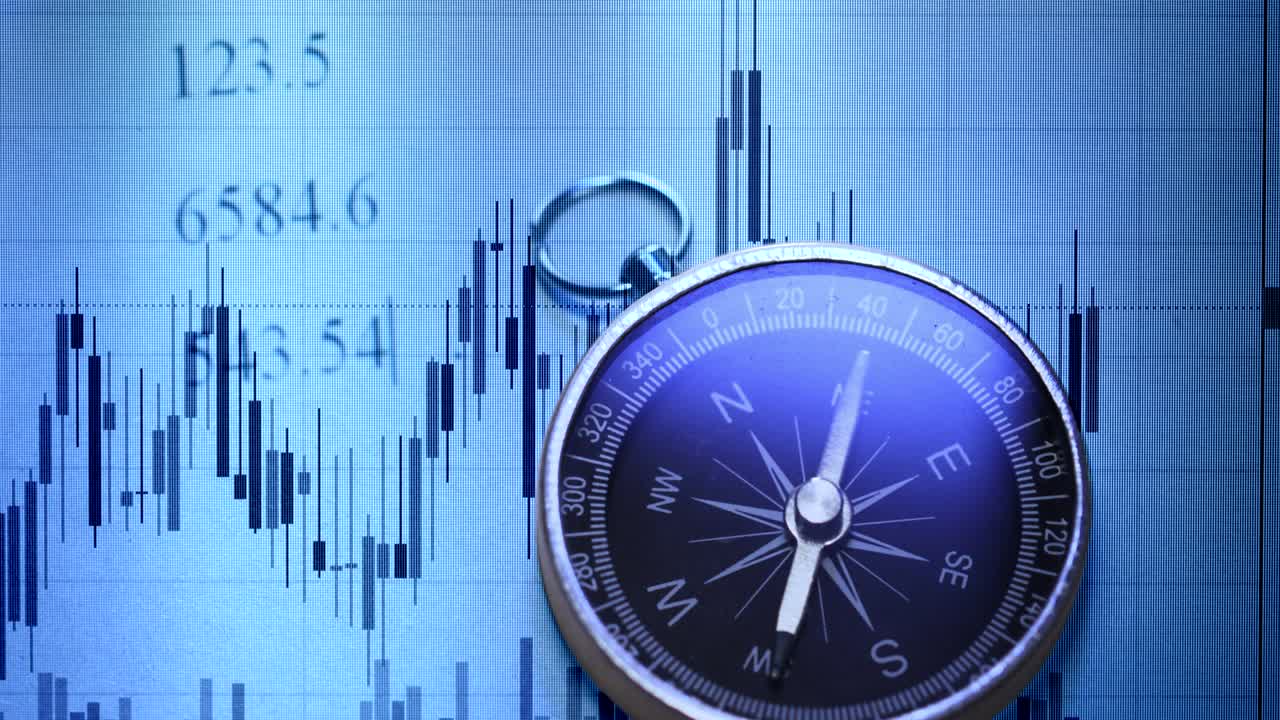 una toma de una brújula con gráfico de comercio