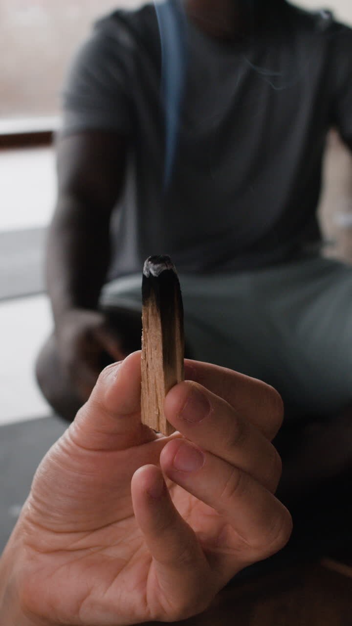 Persona che tiene un bastoncino di incenso Palo Santo.