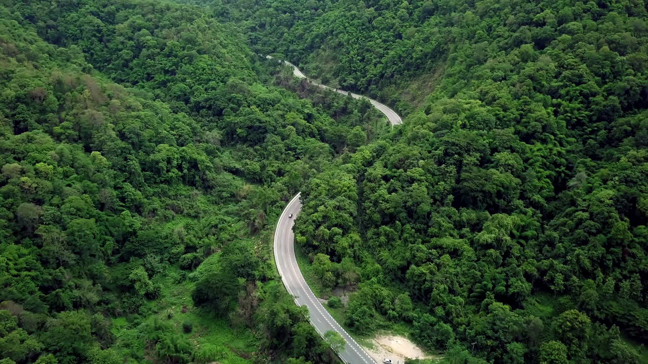 concepto logístico vista aérea de la carretera rural que pasa por la exuberante vegetación y el follaje del bosque tropical lluvioso paisaje montañoso