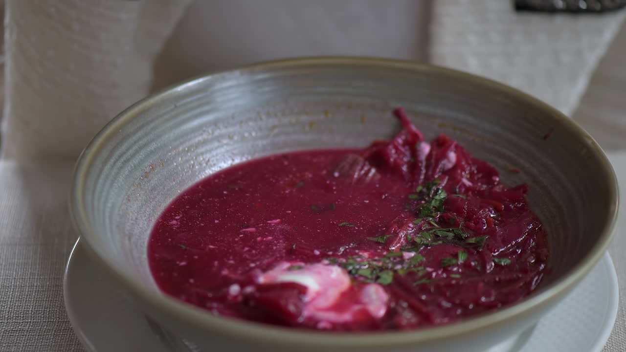 Close up of a woman eating borscht with sour cream at a restaurant