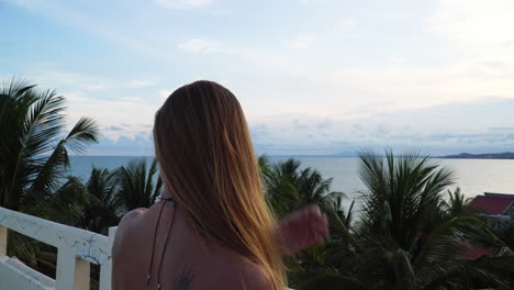 hermosa chica rubia admirando la naturaleza en la terraza