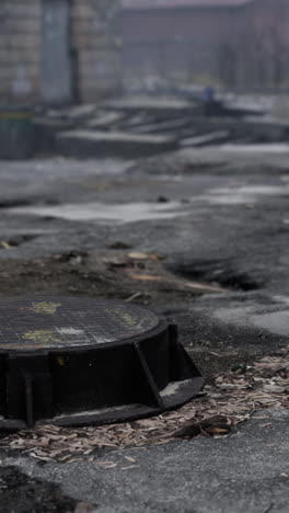 abandoned city: manhole cover in a desolate urban landscape