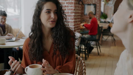 women friends talking in a cafe