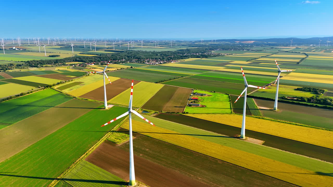 Turbines above colorful fields. Wind turbines stand tall above lush green and golden fields, showcasing renewable energy in a tranquil rural landscape