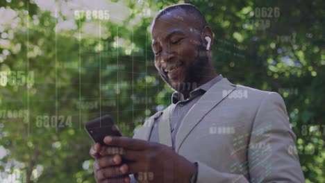 Animation-of-numbers-changing-over-african-american-businessman-laughing-and-using-cellphone