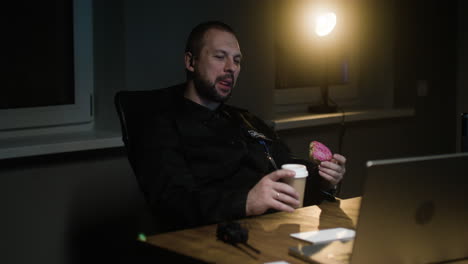 man eating and drinking while talks on the walkie talkie