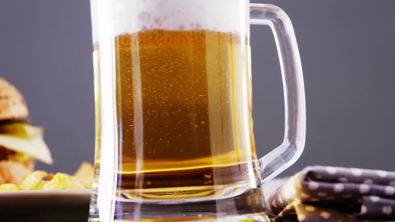 cerveza y hamburguesa contra un fondo gris
