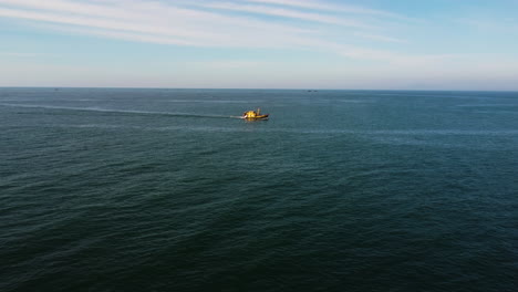 An-aerial-shot-filming-a-fisherman's-boat-going-out-in-Mui-Ne,-Vietnam