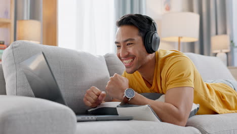 Hombre-En-El-Sofá-Con-Computadora-Portátil,-Auriculares-Y-Deportes