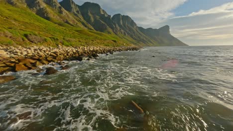 drone flying low above the water revealing the scenic coastal road at kogel bay