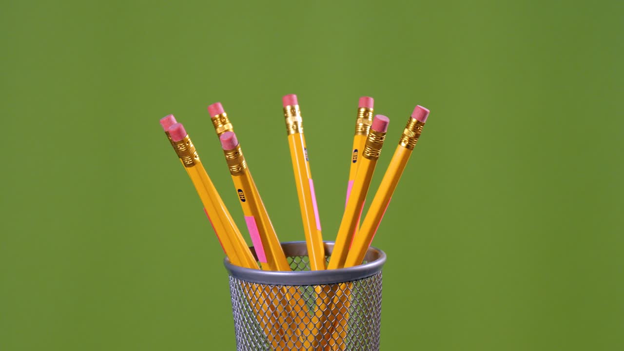 lápices de borrado amarillos girando sobre un fondo verde
