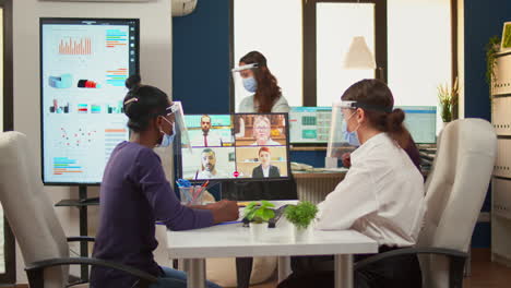 black woman and entrepreneur with protective masks having videocall