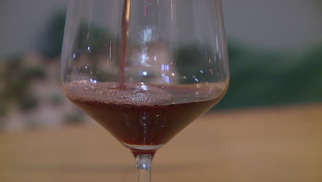 pouring red wine into a glass