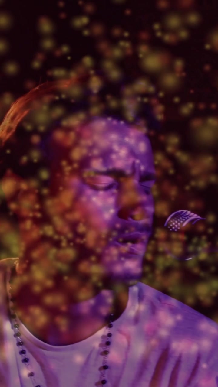Video verticale: Musicista che ascolta musica, si esibisce al microfono, particelle calde che fluttuano, oscurando il viso