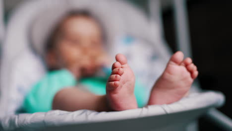 beautiful tiny baby feet. close up. adorable child sitting in a rocking chair peacefully. blurred background.