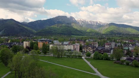 Flyover-of-Zakopane,-Poland,-a-resort-town-village-with-traditional-Goral-architecture-near-the-Polish-Tatra-mountains,-farmland,-forests,-Giewont-peak,-and-Great-Krokiew-Ski-Jump---4K-Static-Shot