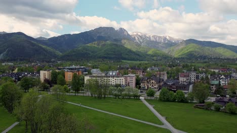 sobrevuelo de zakopane, polonia, un pueblo turístico con arquitectura goral tradicional cerca de las montañas polacas tatra, tierras de cultivo, bosques, pico giewont y gran salto de esquí krokiew - tiro estático 4k