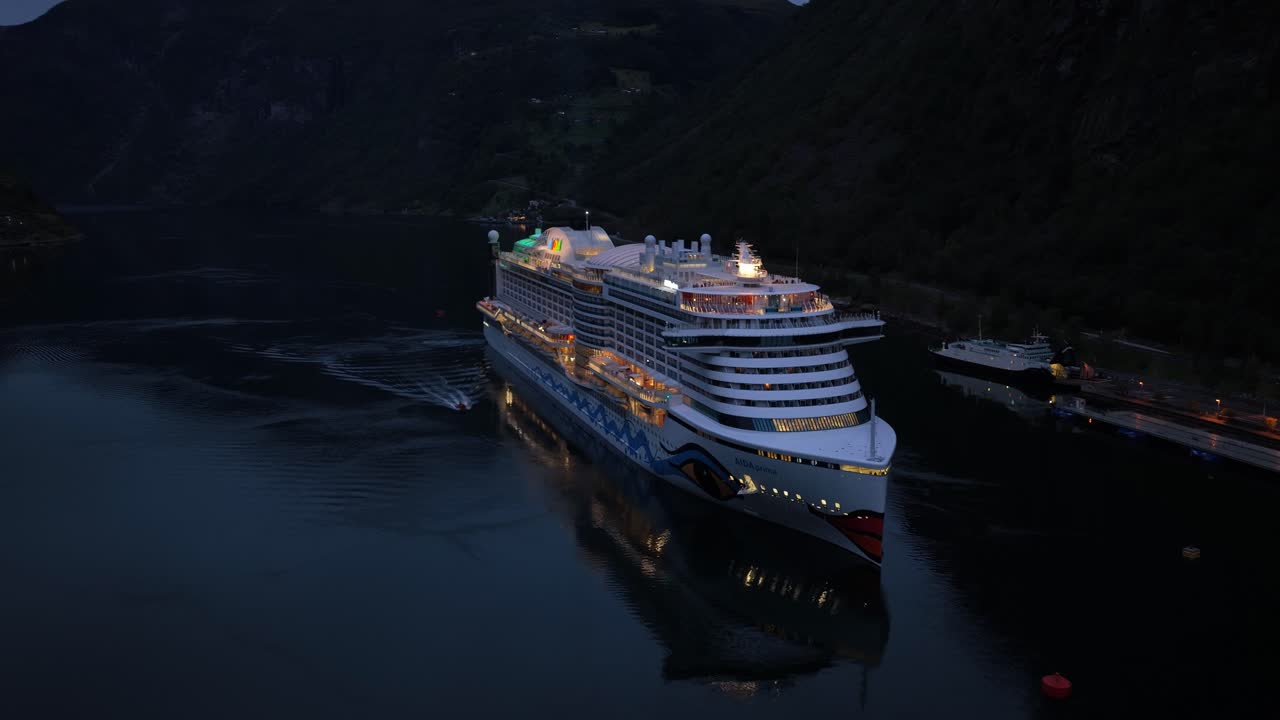 Krydstogtskib set fra oven, sejler ind i fjord ved skumring, Norge