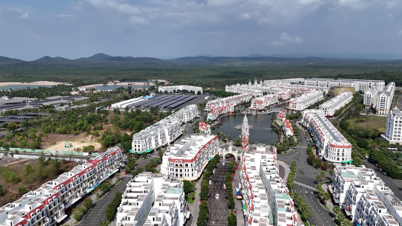 Aerial video of a newly built city and its artificial lake. Tourist destination in Phu Quoc Island, Vietnam, a planned community with unique aesthetic architecture. Theme Park and hotels.