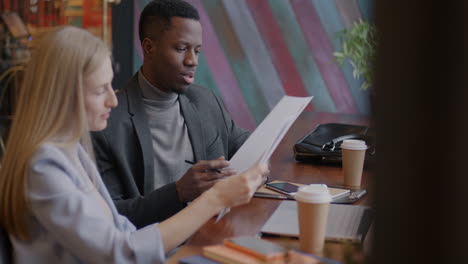 business colleagues discussing documents in a coffee shop