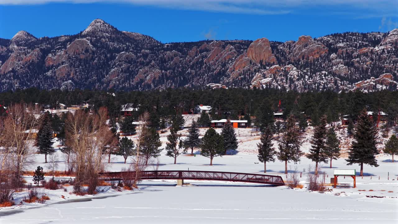 Estes Park -järvi, kävelysilta, Lumpy Ridge Twin Sisters, talvi, lumi, aamu, aurinkoinen sininen taivas, drone-ilmakuva, Coloradon Front Range, Rocky Mountainin kansallispuisto, RMNP, Continental Divide, Larimerin piirikunta, ympyrä.