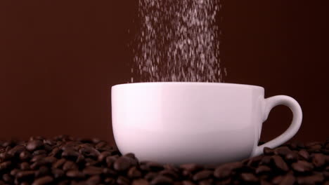 azúcar vertiendo en taza de café blanca