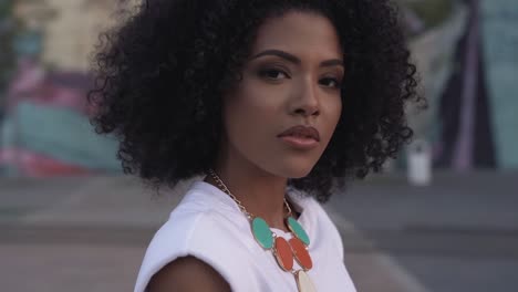 beautiful black afro brazilian woman walking and making eye contact, close up