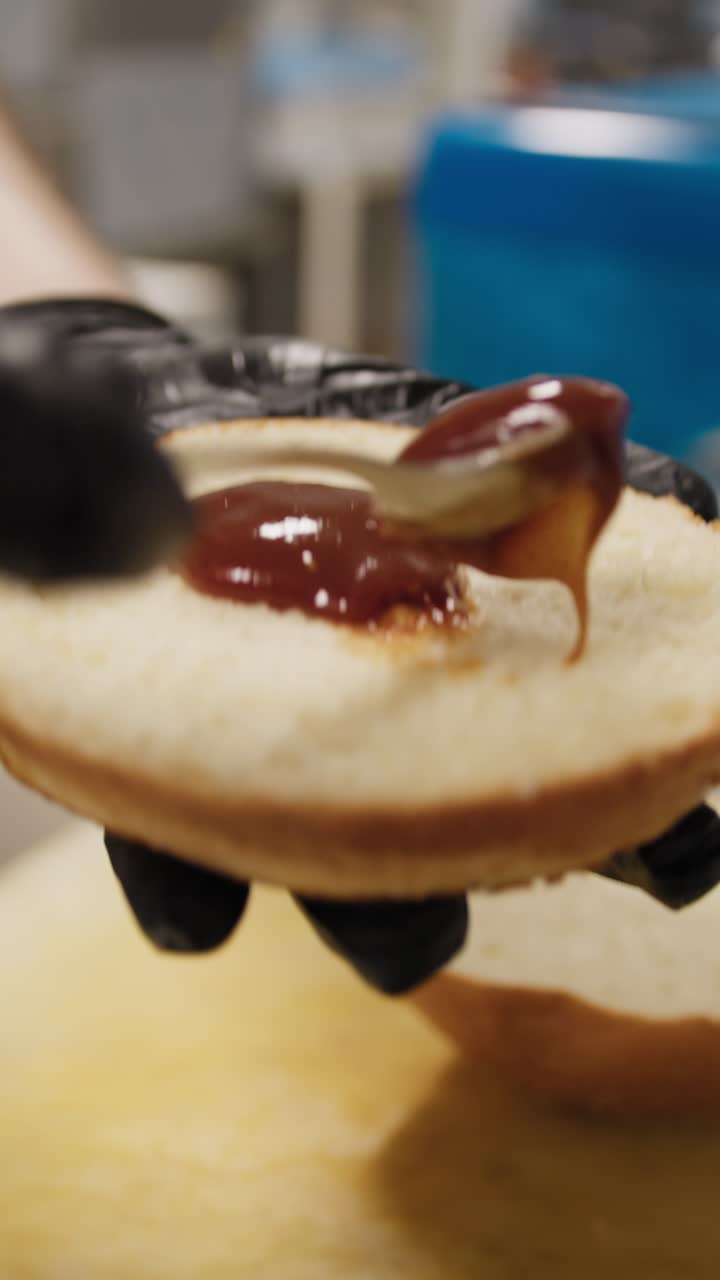 Chef Putting And Spreading Barbecue Sauce On The Burger Bread