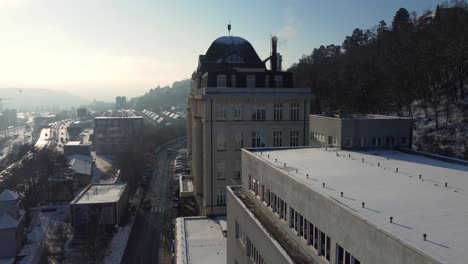 Prague-CSSZ-building-in-Smichov,-flying-birds,-aerial-drone-sunny-day-side-view,-Czech-Republic