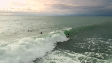 dark clouds provide a dramatic backdrop for silhouetted surfers.