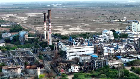aerial view of a large pharmaceutical factory in chennai. the complex features various buildings, processing units, and tall stacks, symbolizing advanced drug manufacturing and innovation