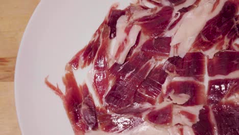 gourmet spanish jamon iberico rotating on white plate with copy space on left