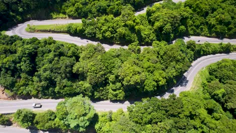 Curvy-road-through-dense-green-forest-in-Sri-Lanka,-aerial-view