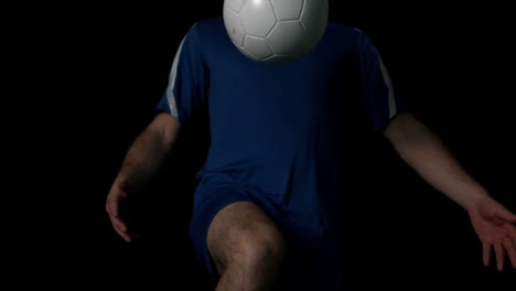 footballer controlling the ball on black background