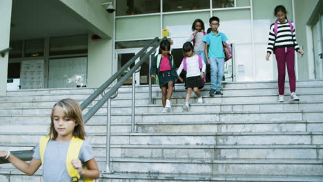 niños multiétnicos bajando las escaleras después de las lecciones