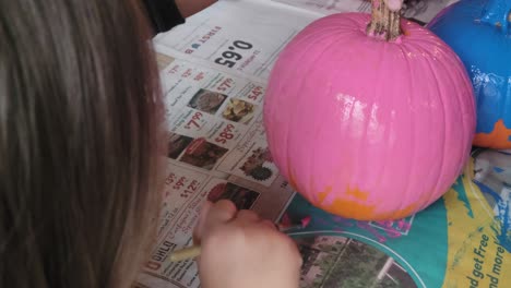 preschool child painting pumpkin