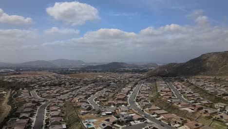 Cloudy-day-drone-shot-slowly-reveals-the-patchwork-of-light-and-shadow-over-a-Riverside,-California-neighborhood