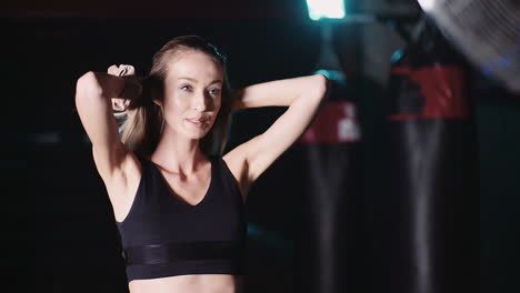 cámara lenta de atleta femenina atractiva sonriente moviendo las manos a través del cabello en el club de salud 8