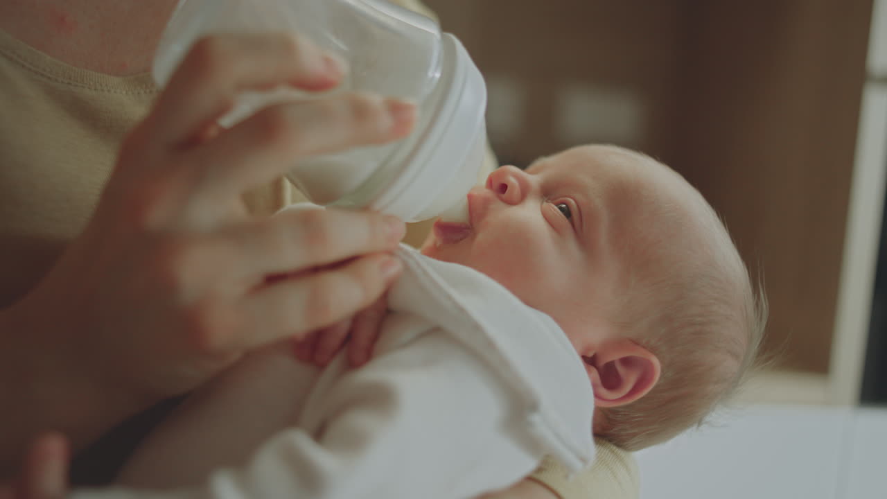 madre alimentando al bebé con el biberón
