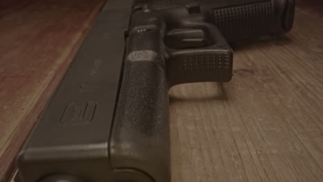 stunning macro dolly out of glock 17 handgun on a wooden surface