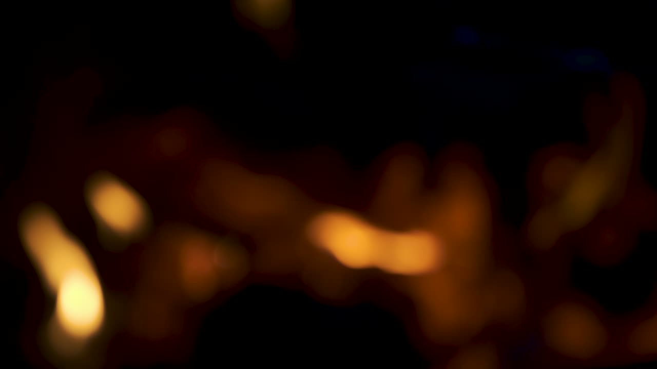 Blurry stove with burning fire. Beautiful colored bokeh of BBQ flames. Blurred background with burning firewood in the fireplace close up