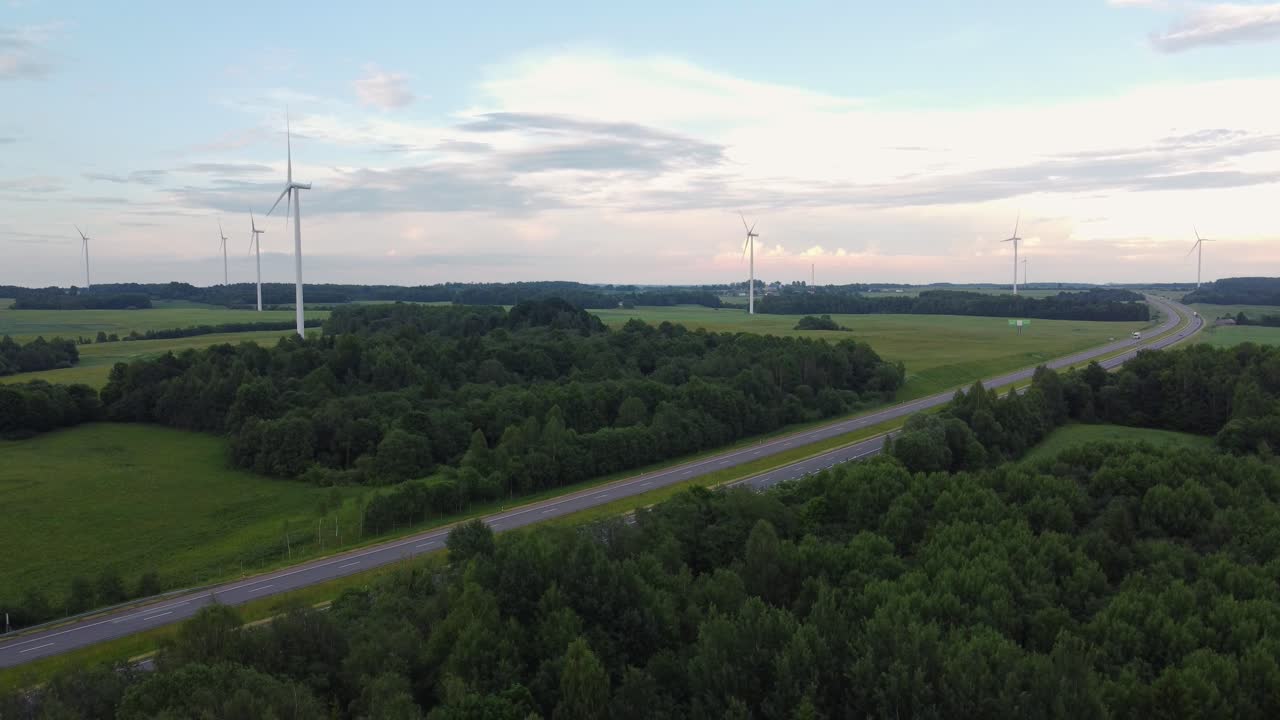Highway road and wind turbines, aerial descent view