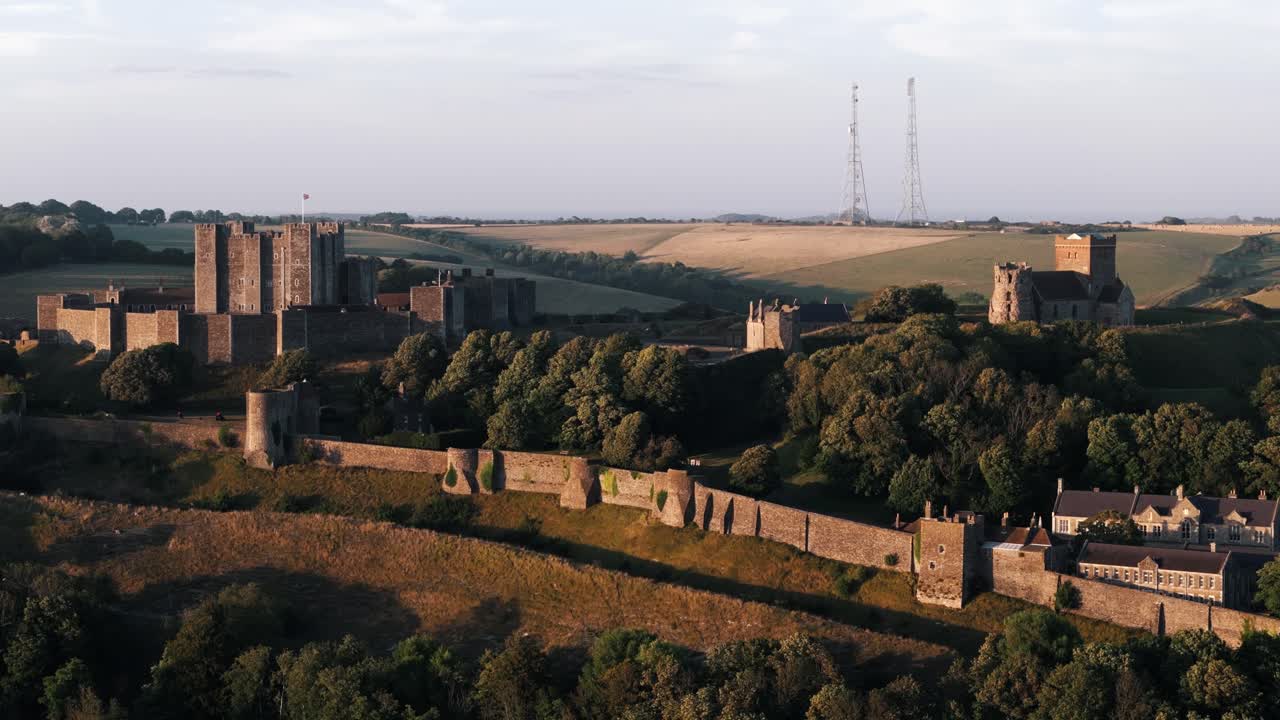 Slow circle of Dover Castle with surrounding green fields in soft sunset light