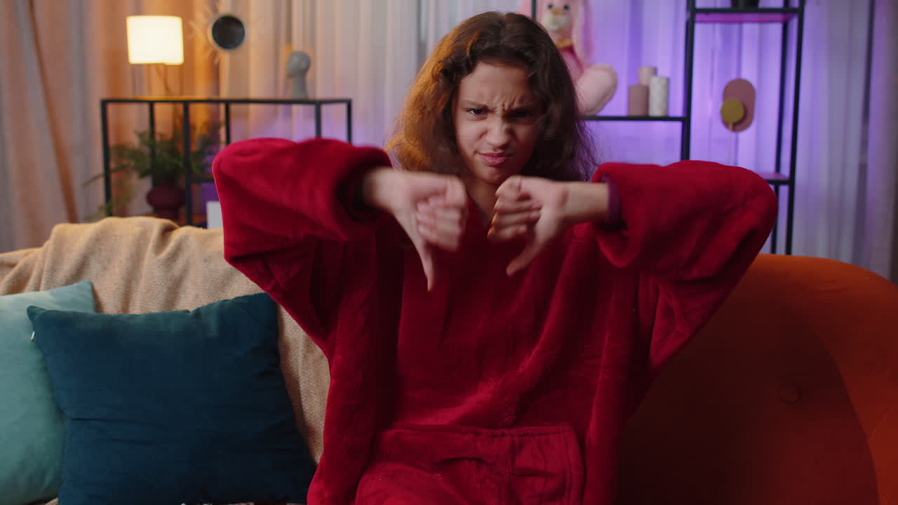 chica joven molesta mostrando pulgares hacia abajo, no le gusta el mal trabajo, desaprobación, retroalimentación insatisfecha en casa